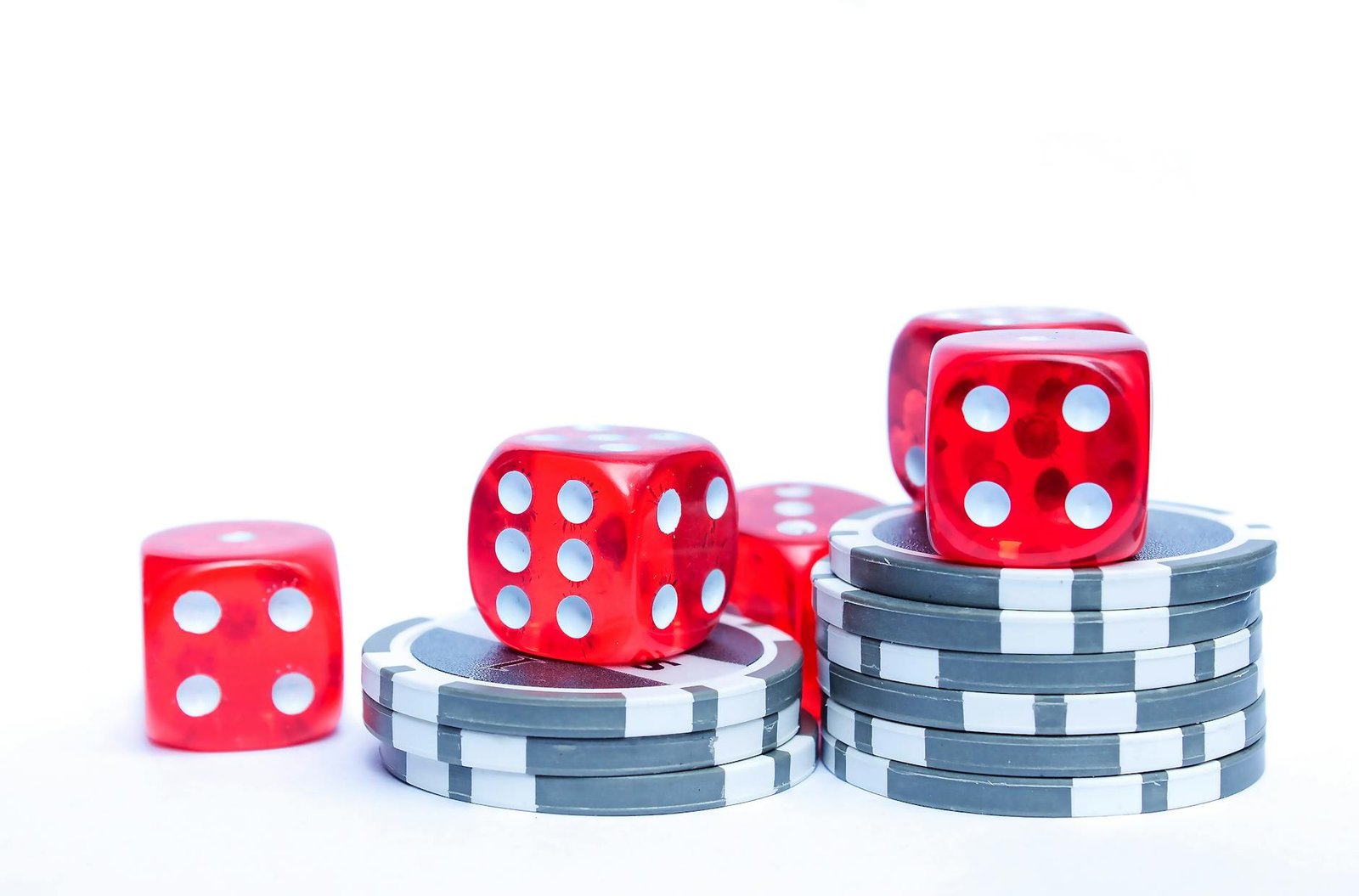 Dados e fichas de cassino sobre mesa vermelha