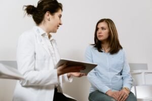 Profissional de saúde conversa com paciente em hospital