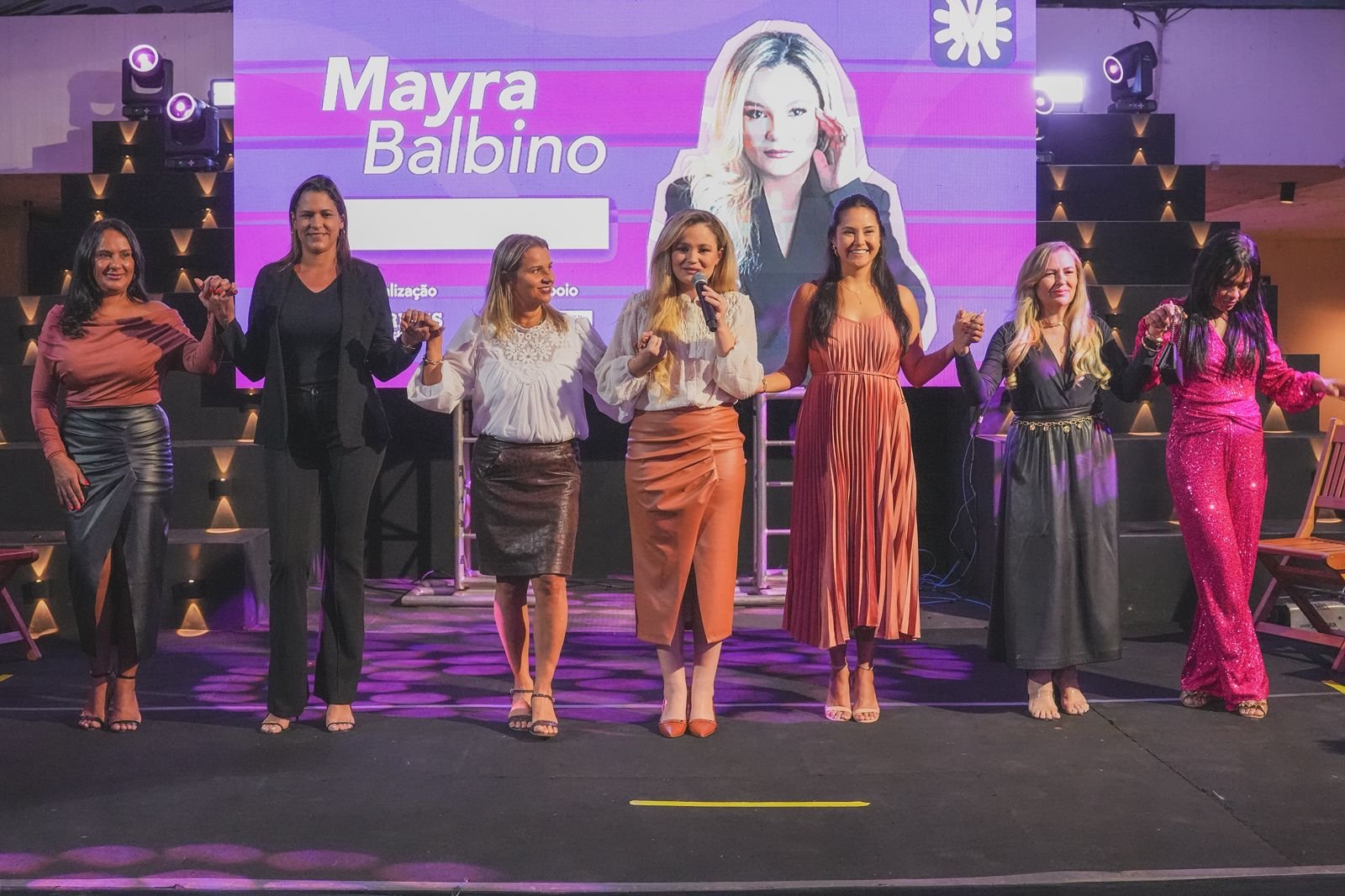 Apresentação do podcast Viva Mulher no palco, com participantes da série