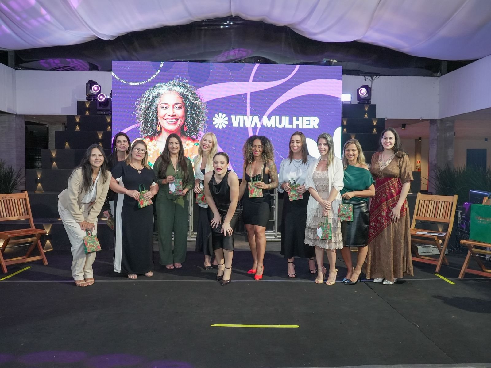 Equipe do Viva Mulher em evento de lançamento, com backdrop oficial do projeto