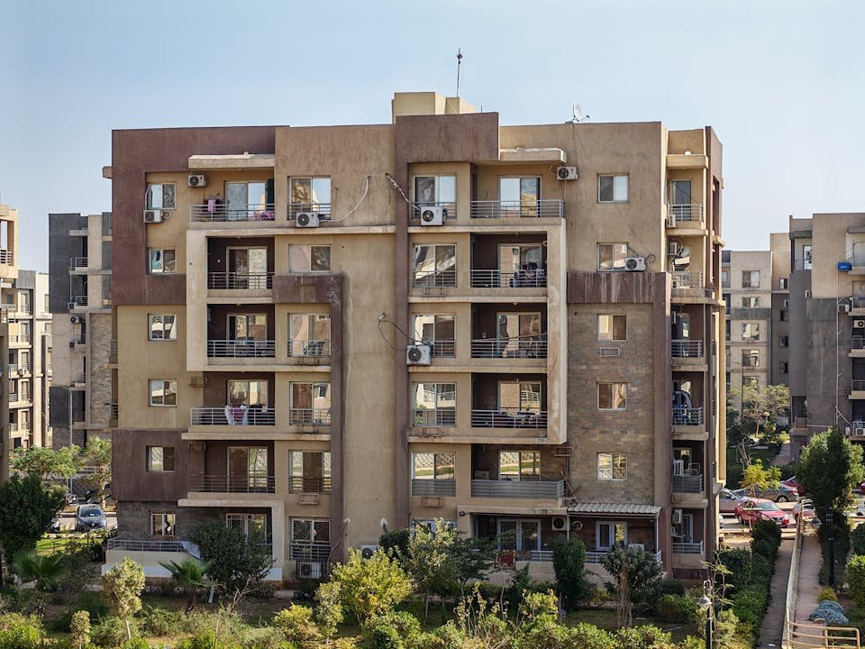 Predio residencial com varandas e ar-condicionado em area arborizada