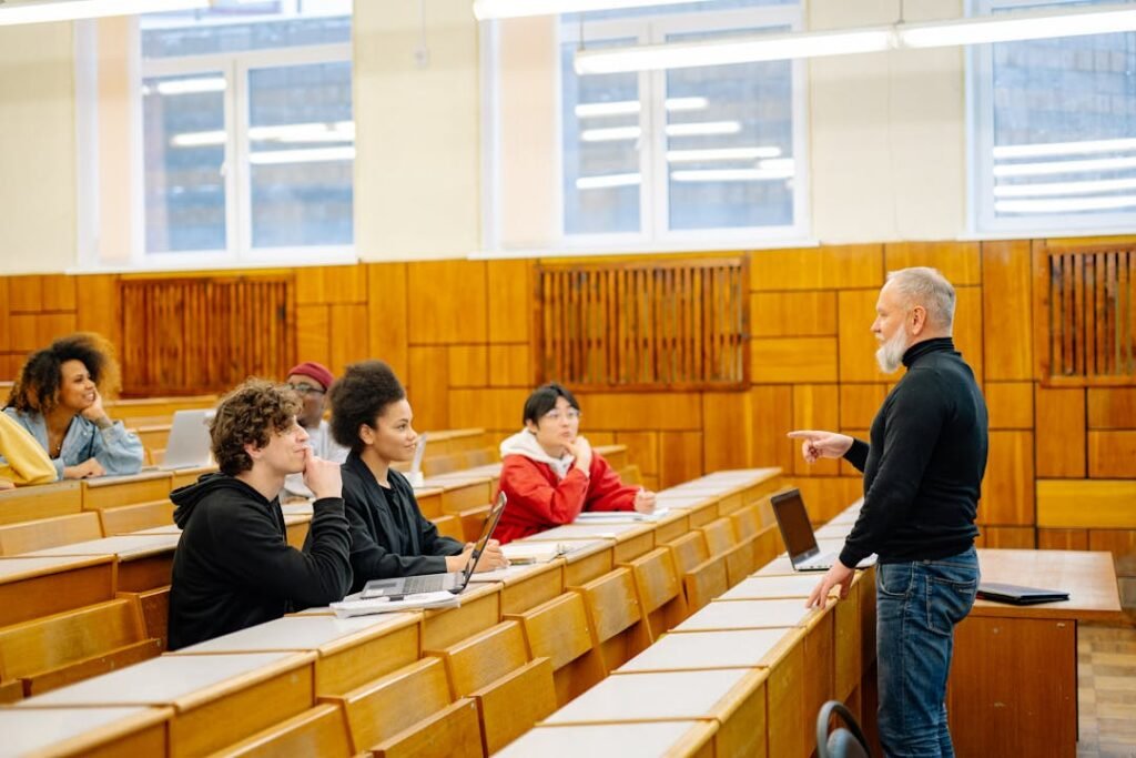 Professor maduro em sala universitaria de paredes de madeira com alunos sentados