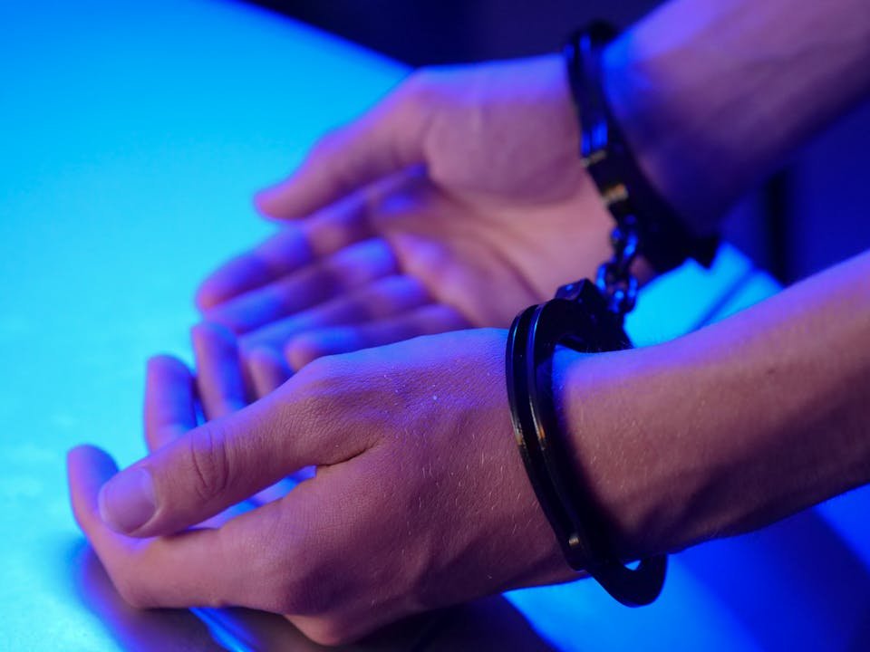 Maos algemadas sobre superficie em ambiente com iluminacao azulada