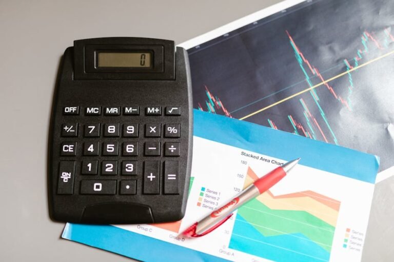 Calculadora preta sobre relatórios financeiros com caneta