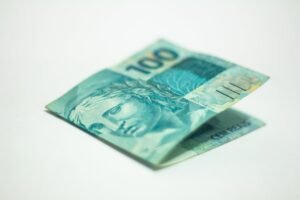 Cédula brasileira de R$ 100 reais dobrada em fundo branco