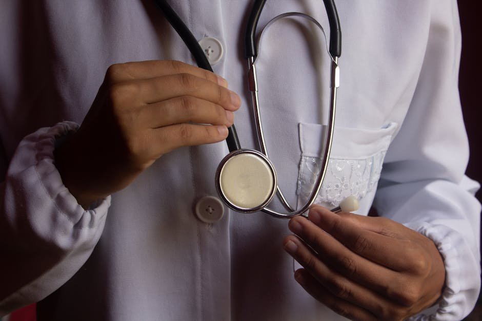 Profissional de saúde de jaleco branco segurando estetoscópio