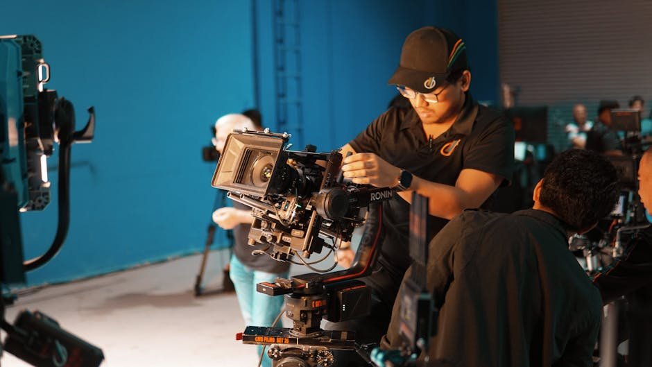 Equipe de cinema posicionando câmera profissional em estúdio