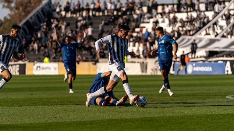 Jogadores de futebol disputando lance em estadio