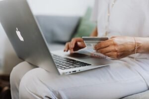 Mãos no teclado de notebook em mesa de trabalho