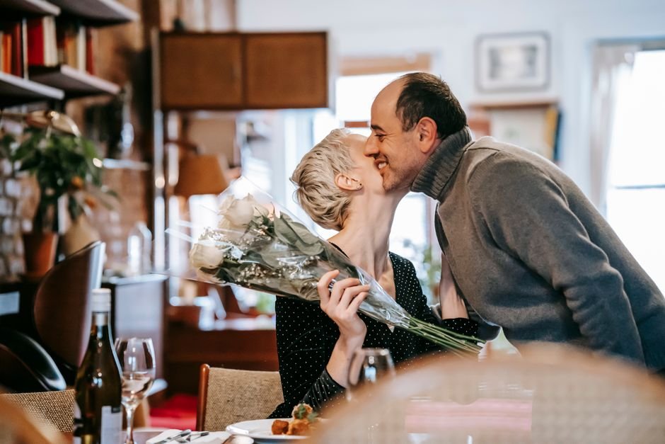 Casal segurando flores em ambiente acolhedor