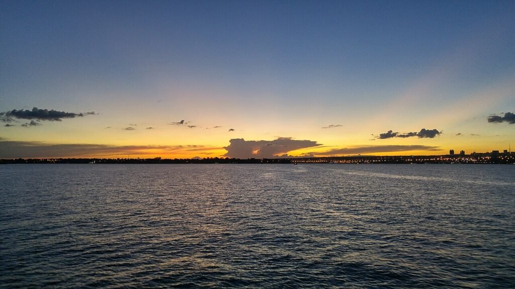Vista do Lago Paranoá, em Brasília, ao entardecer, com a orla da cidade ao fundo