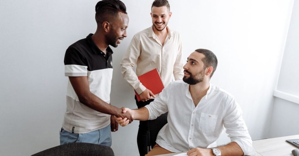Aperto de mãos entre candidato e recrutador em uma mesa de escritório após entrevista de emprego