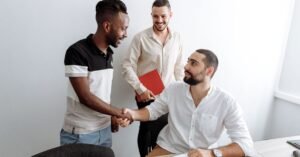 Aperto de mãos entre candidato e recrutador em uma mesa de escritório após entrevista de emprego