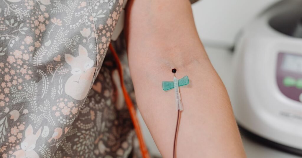 Braço de paciente com dispositivo de acesso venoso fixado por curativo em ambiente hospitalar