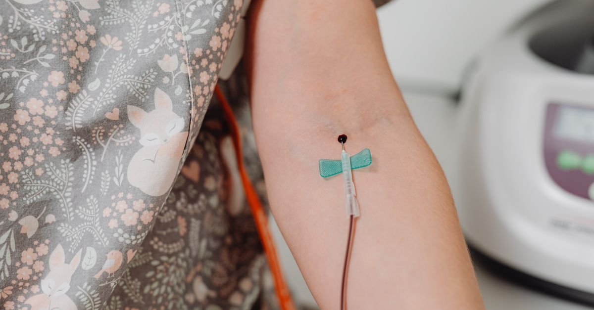 Braço de paciente com dispositivo de acesso venoso fixado por curativo em ambiente hospitalar