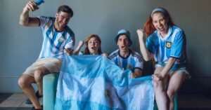 Torcedores com a camisa da Argentina comemoram com a bandeira do país