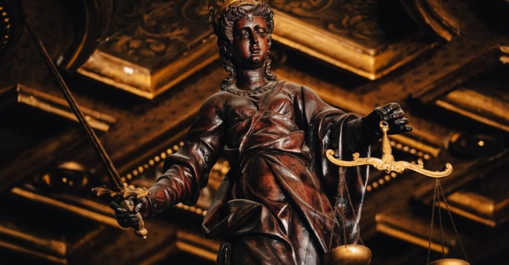 Estatua da Justica com balanca dourada em ambiente de tribunal