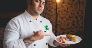 Chef de dólmã branca com bandeira do Brasil apresenta prato com carne e batatas
