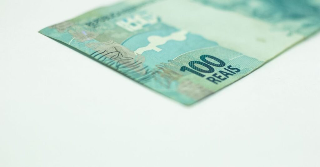 Cédula de cem reais em close sobre fundo branco