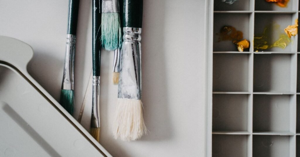 Pincéis e godê com tintas em ateliê de arte