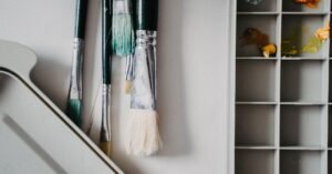 Pincéis e godê com tintas em ateliê de arte