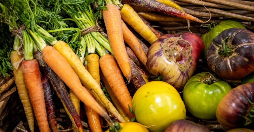 Cenouras, tomates e legumes frescos em cesta de vime
