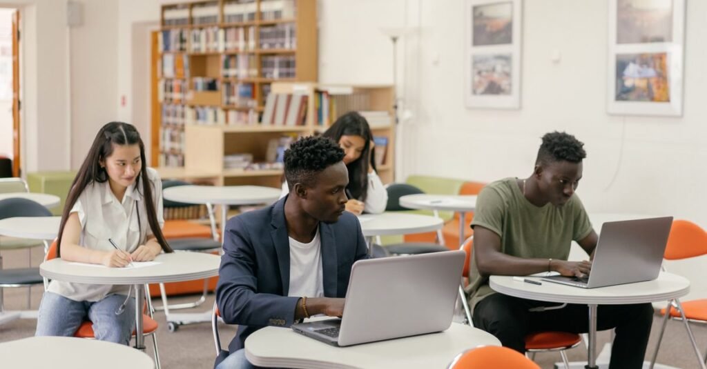 Estudantes usando notebooks em biblioteca durante estudo