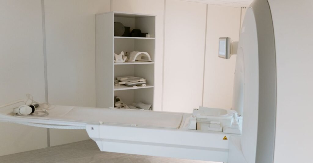 Sala de exames de imagem com equipamento de tomografia e maca posicionada para o paciente
