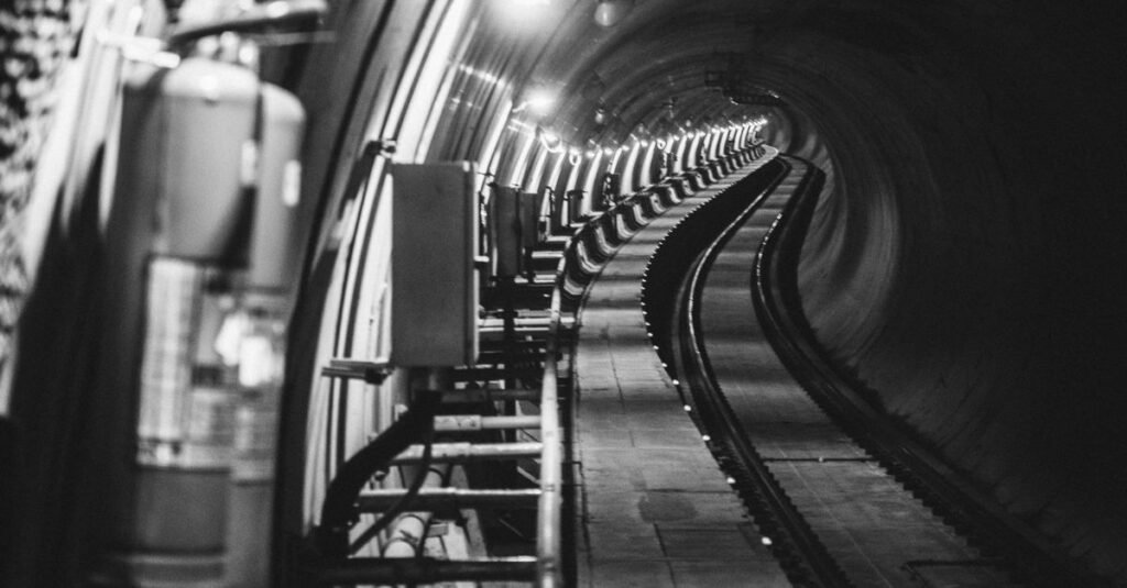 Túnel de metrô com trilhos em curva visto da lateral da via