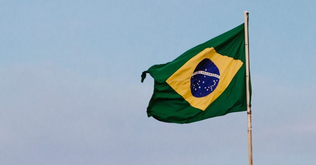 Bandeira do Brasil tremulando em mastro contra céu azul