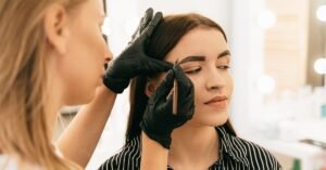Profissional faz design de sobrancelha em cliente em estúdio de beleza