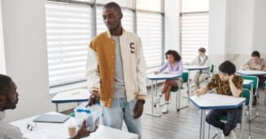 Estudantes sentados em carteiras durante aplicação de prova em sala de aula