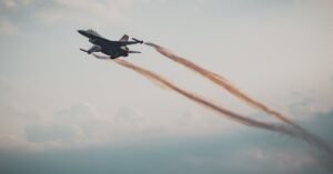 Caça militar em voo entre nuvens durante operação aérea