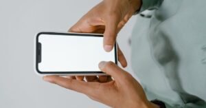 Mãos segurando um celular com a tela em branco