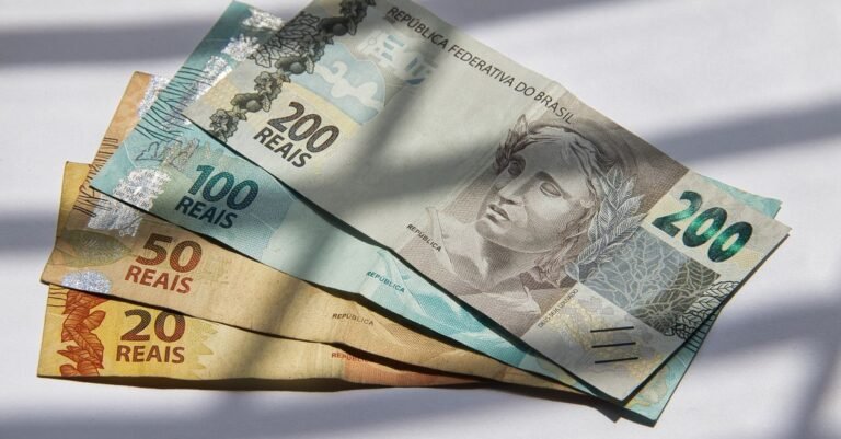 Cédulas de real de 200, 100, 50 e 20 dispostas sobre superfície clara