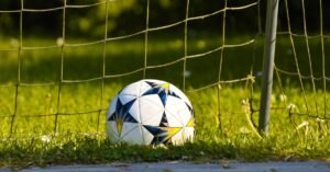 Bola de futebol dentro do gol sobre o gramado