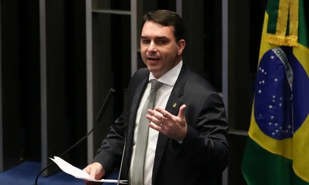 Flávio Bolsonaro discursa na tribuna do Senado, com bandeira do Brasil ao fundo