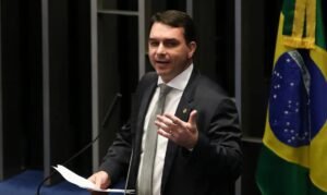Flávio Bolsonaro discursa na tribuna do Senado, com bandeira do Brasil ao fundo