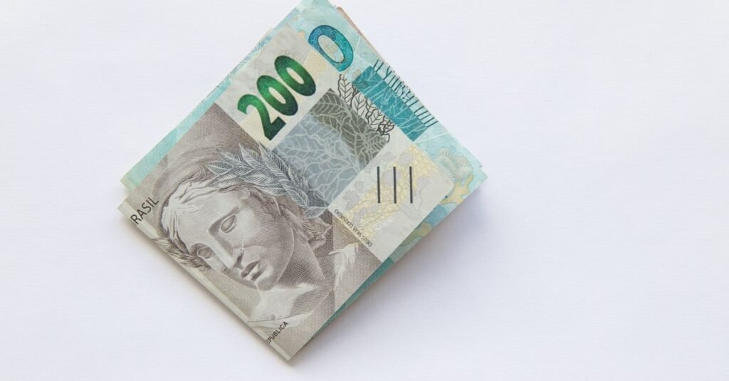 Cedulas de duzentos reais dobradas sobre fundo branco
