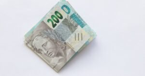 Cedulas de duzentos reais dobradas sobre fundo branco
