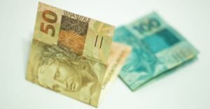 Cédulas de 50 e 100 reais sobre fundo claro