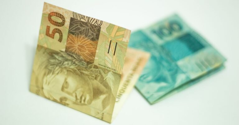 Cédulas de 50 e 100 reais sobre fundo claro