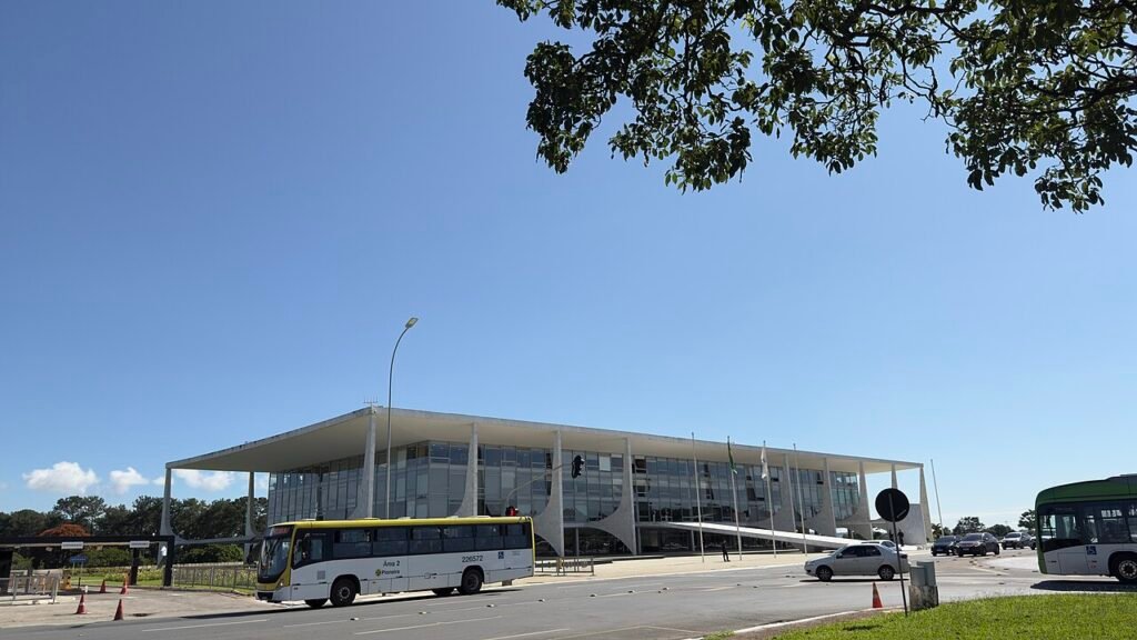 Fachada do Palácio do Planalto vista da via, com ônibus do transporte público em primeiro plano