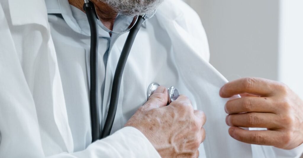 Médico de jaleco branco segura estetoscópio durante atendimento