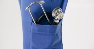 Estetoscopio no bolso de uniforme azul de profissional de enfermagem