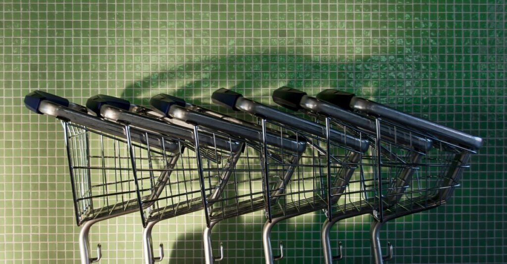 Carrinhos de supermercado enfileirados diante de parede verde