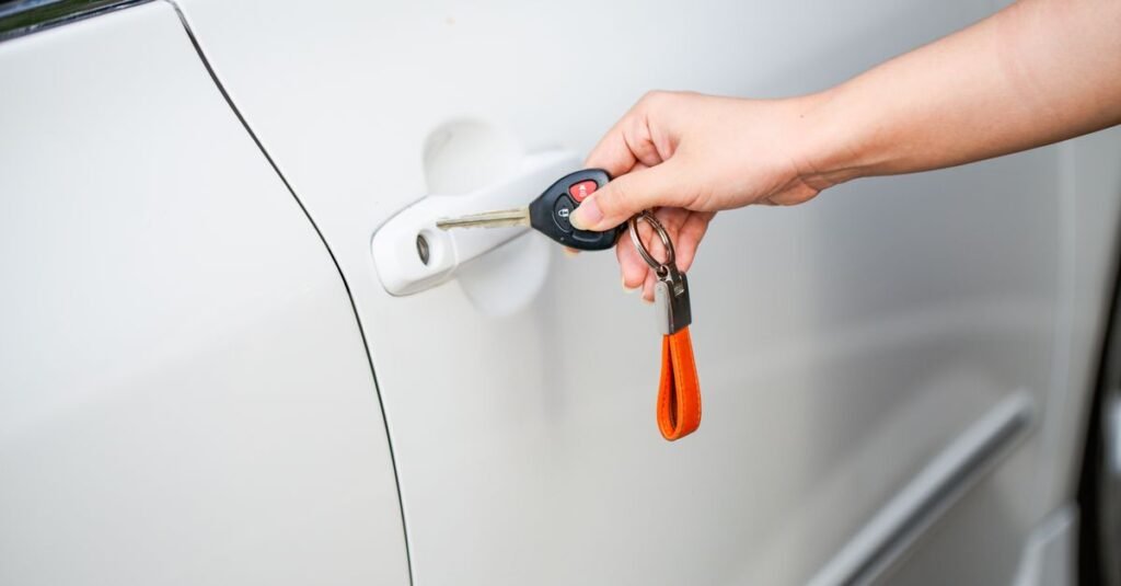 Mão destranca a porta de um carro com a chave