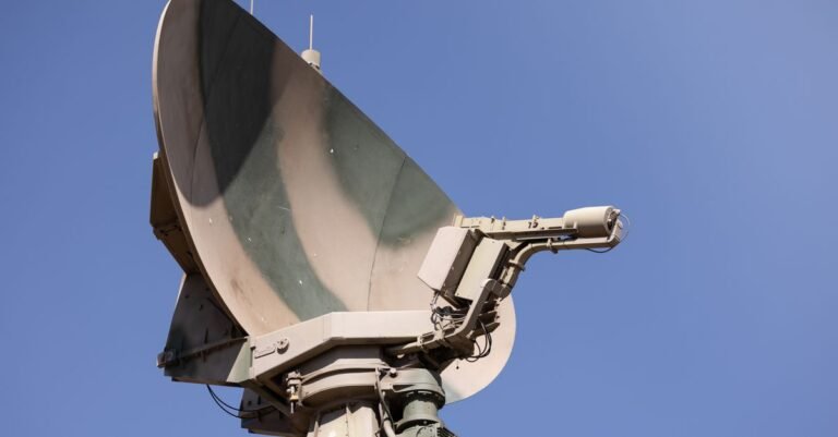 Radar militar camuflado apontado para o céu azul