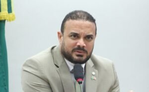 Deputado fala ao microfone durante reuniao de comissao na Camara dos Deputados