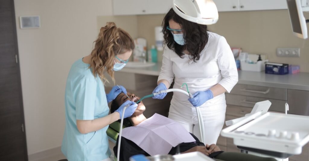 Dentistas atendem paciente em consultorio odontologico